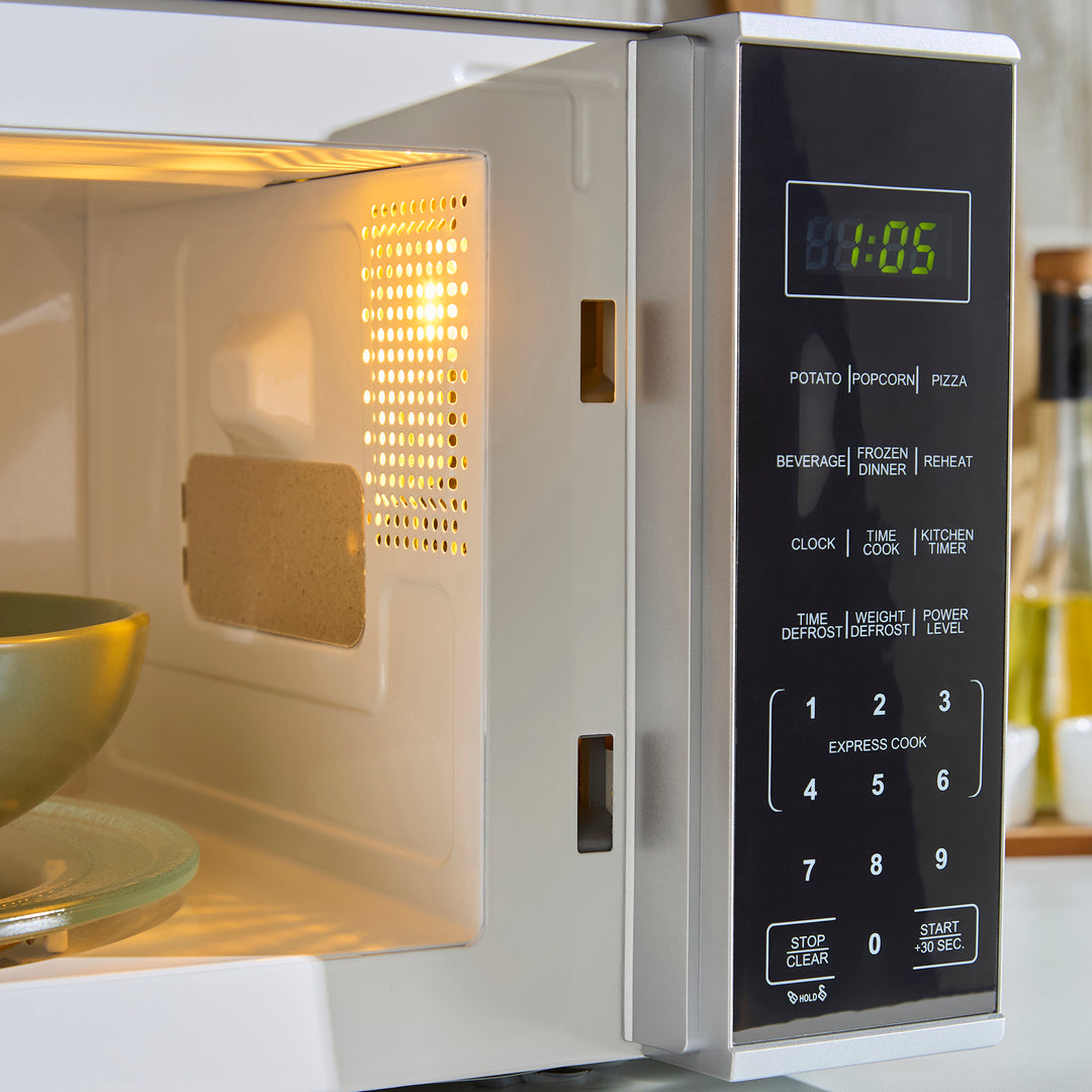Microwave oven with digital display and control panel, showing the time '00:05'.