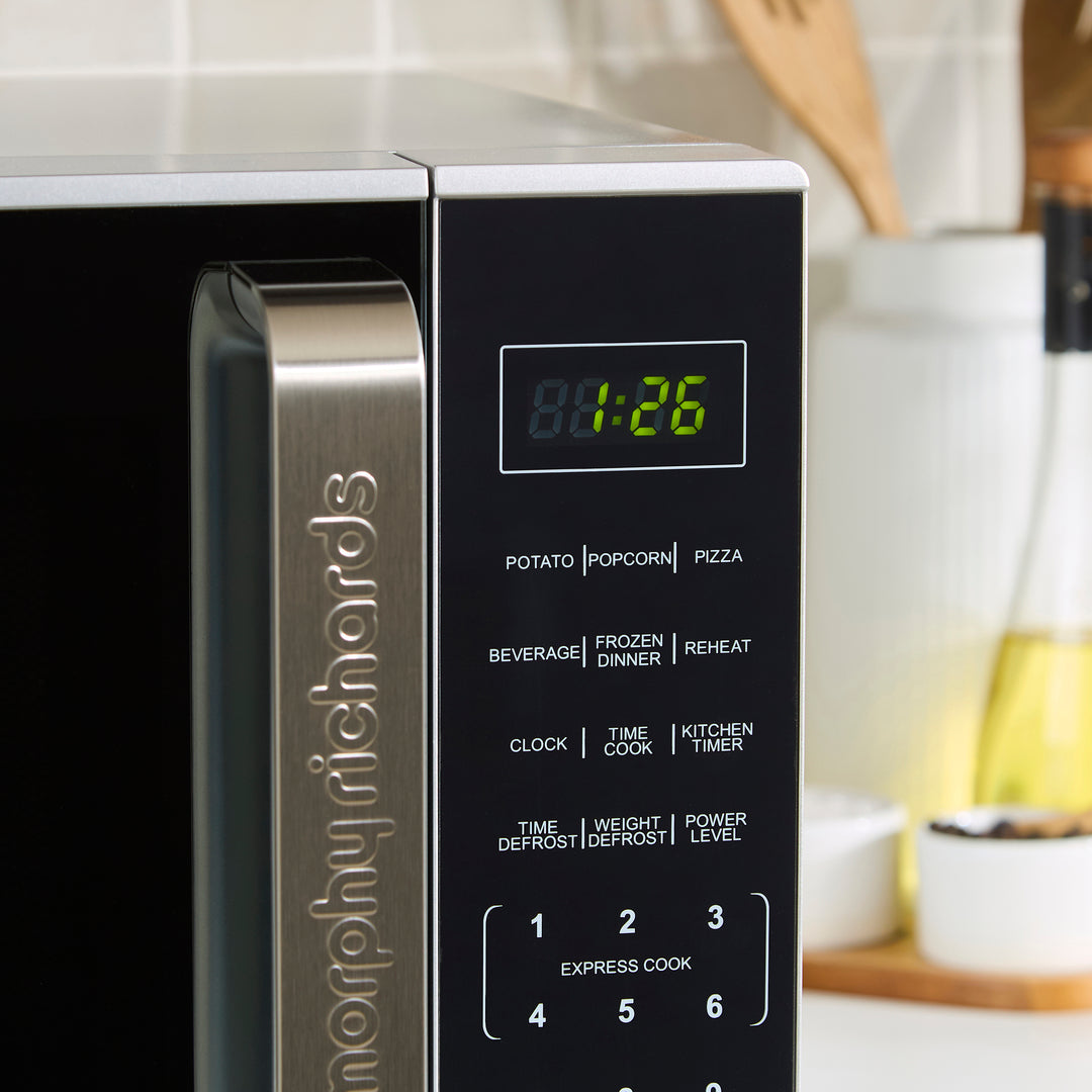 Close-up of a Morphy Richards microwave with digital display and control panel.