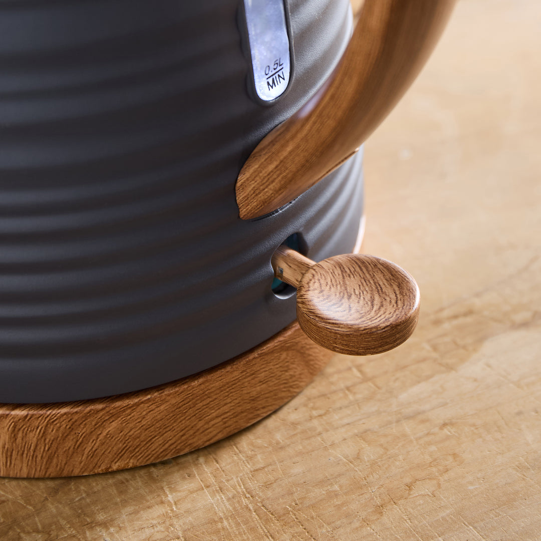 Close-up of a kettle with wooden accents on a wooden surface