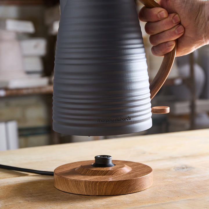 Ceramic kettle with wooden handle on a wooden surface, brand 'moooi' visible