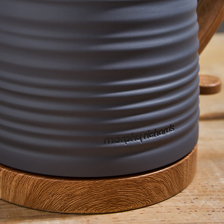 Close-up of a gray kettle with wooden base on a wooden surface, featuring the Morphy Richards brand.