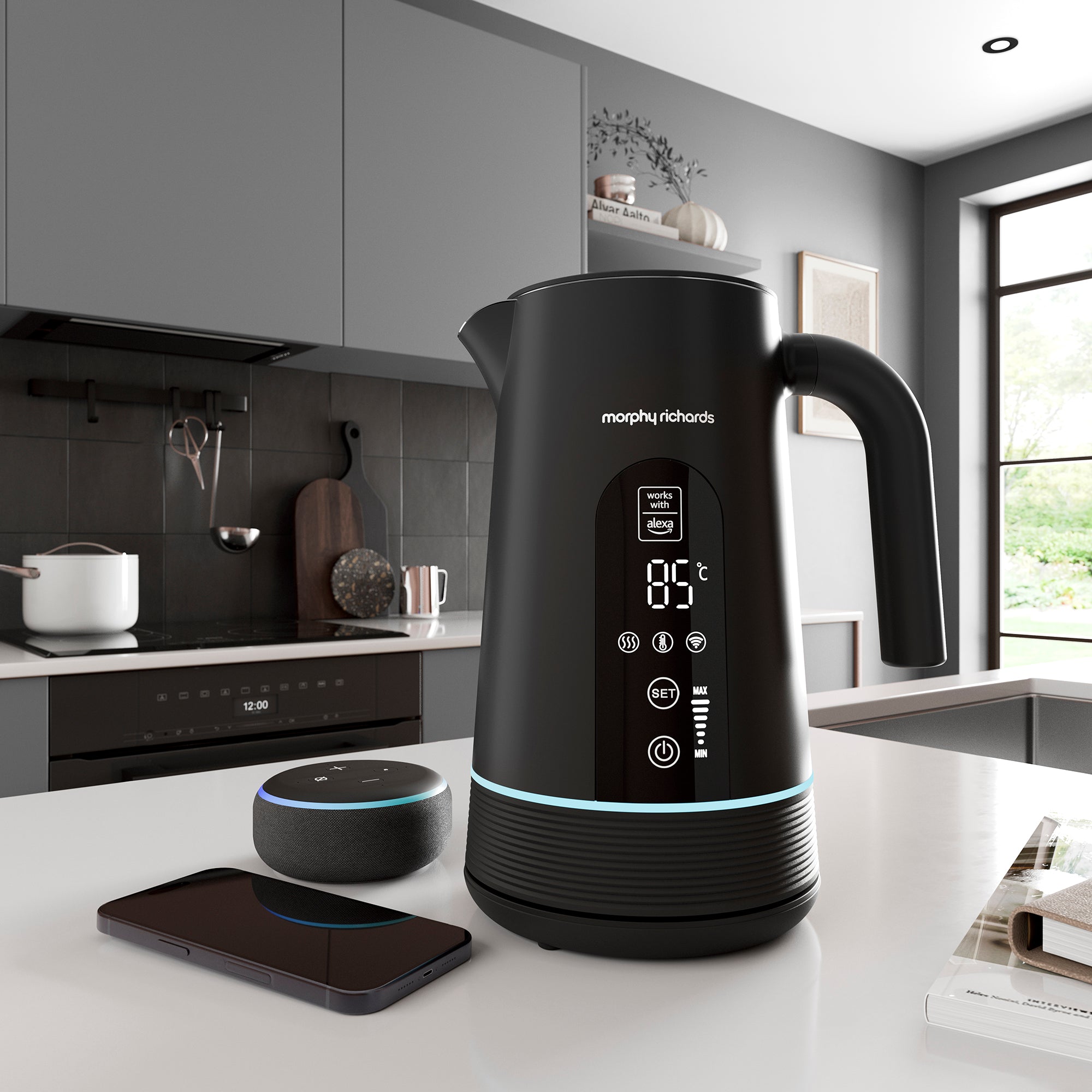 Black Morphy Richards Alexa kettle on a kitchen counter with smartphone and smart speaker.