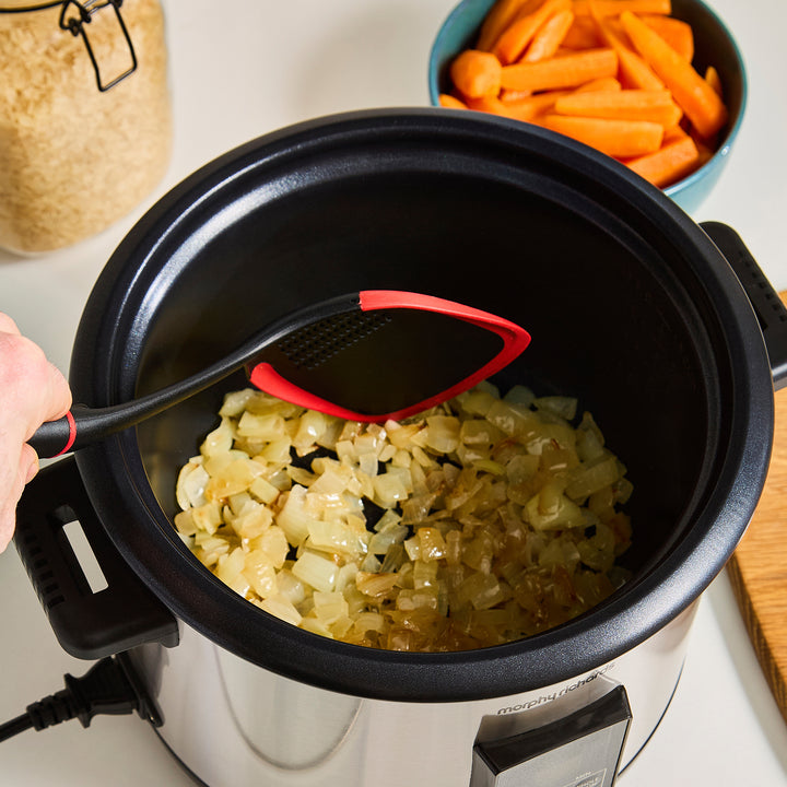 Morphy Richards rice cooker with onions being stirred, carrots in the background
