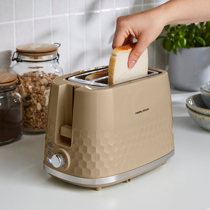 placing bread into a beige 2 slice toaster