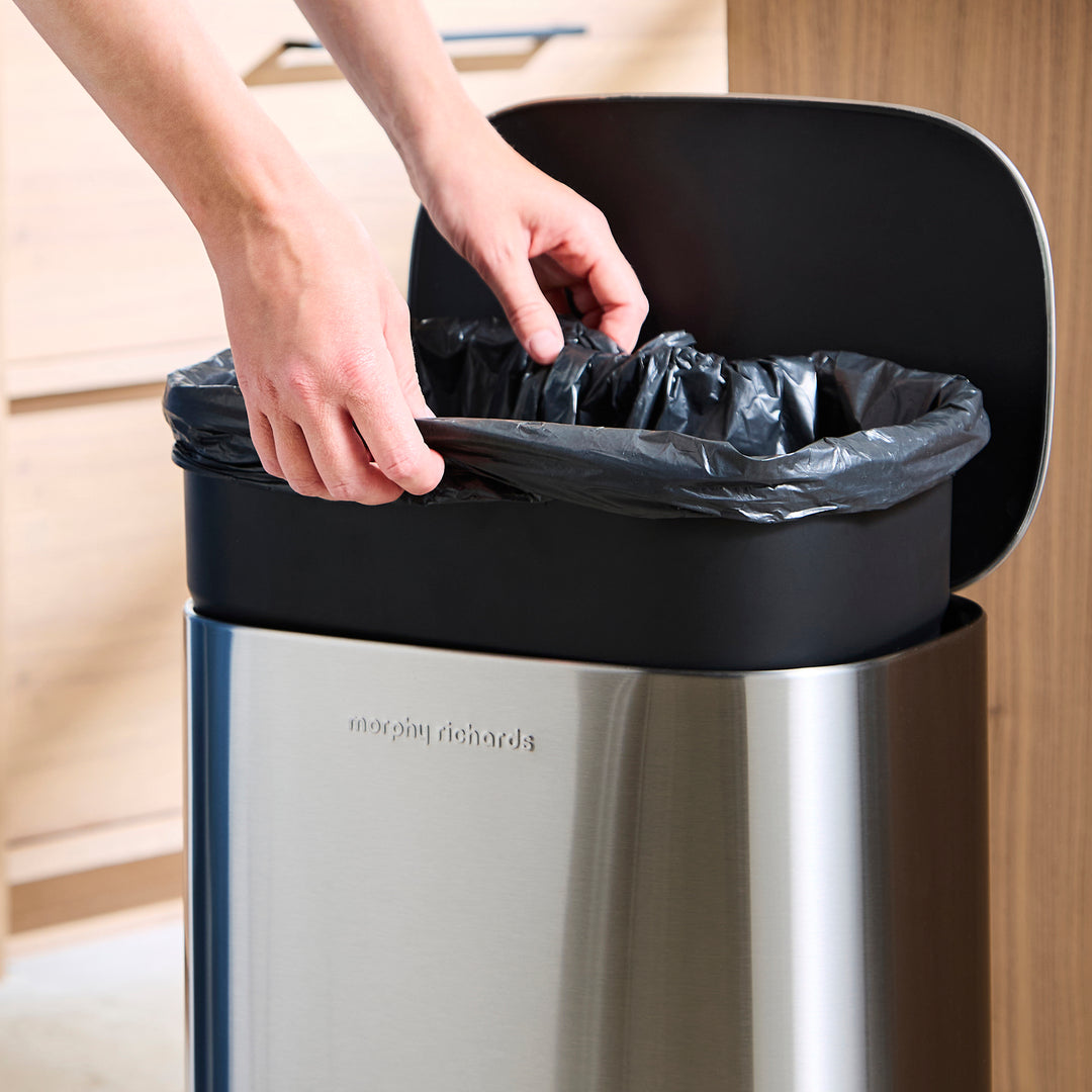 Someone taking the liner out of the bin