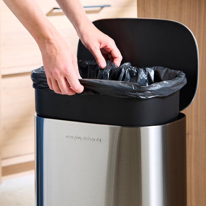 Someone taking the liner out of the bin