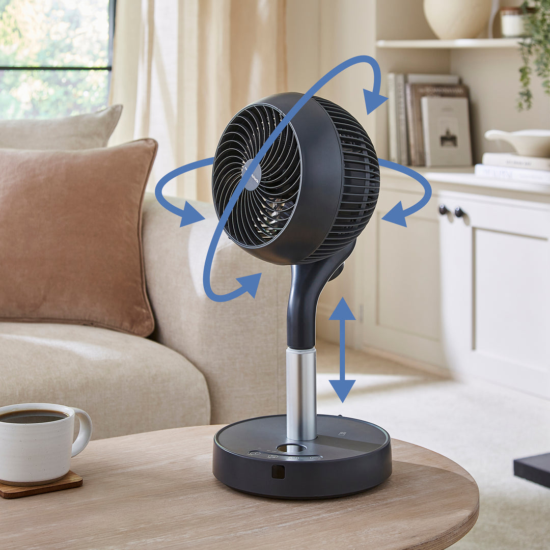 Tabletop fan on a coffee table with arrows indicating airflow in a living room setting.