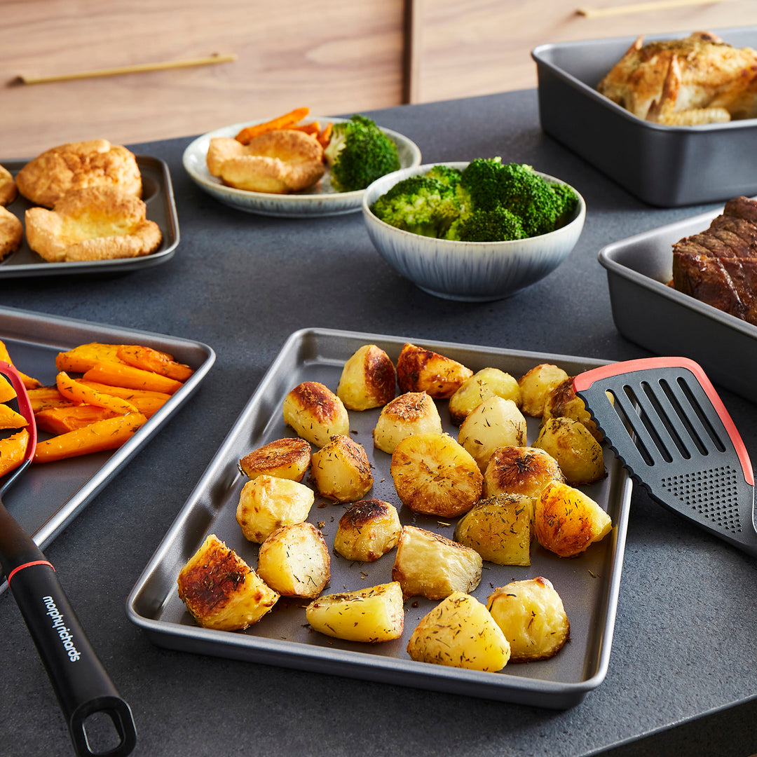 Assorted food items including roasted potatoes, broccoli, and other dishes on a table.