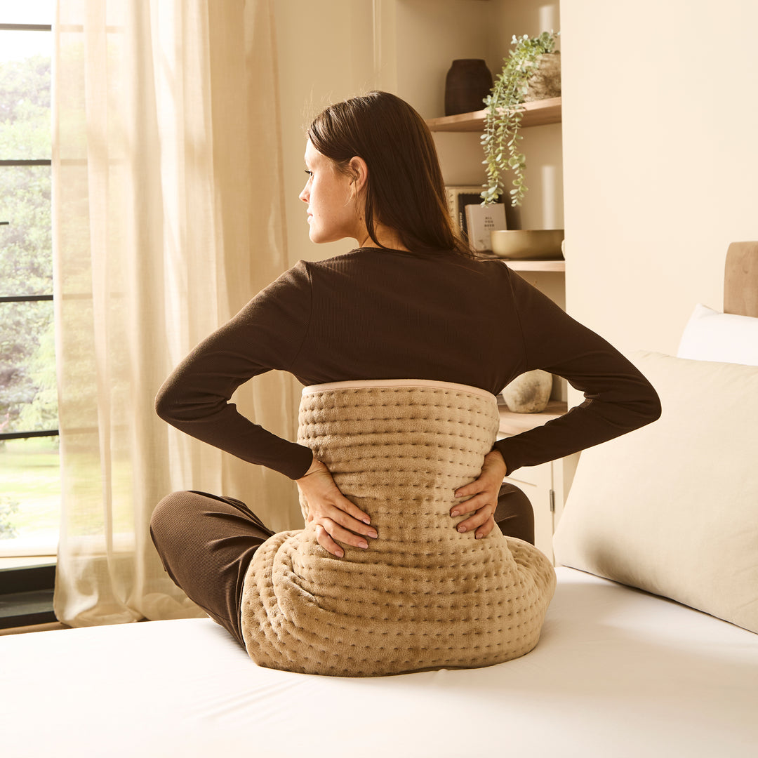 Woman with heat pad wrapped around her back