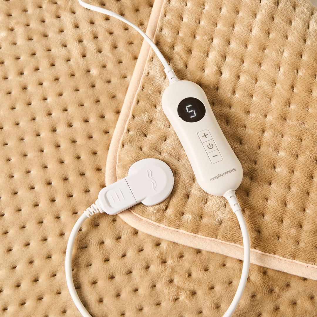 Beige heat pad with white remote control. 