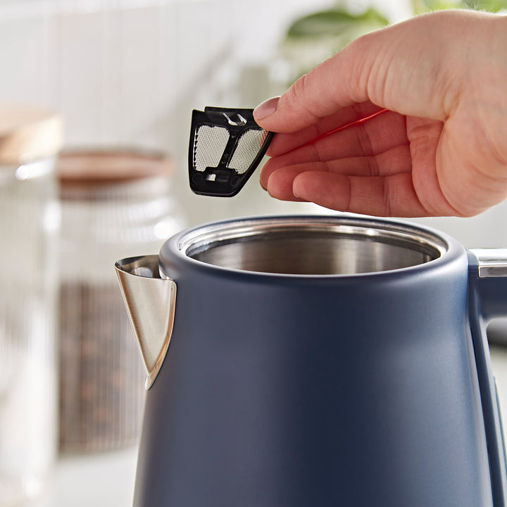 someone removing the filter from the blue kettle