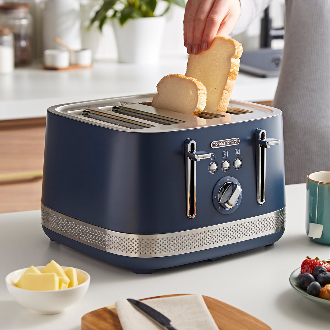 someone placing bread inside the 4 slice toaster