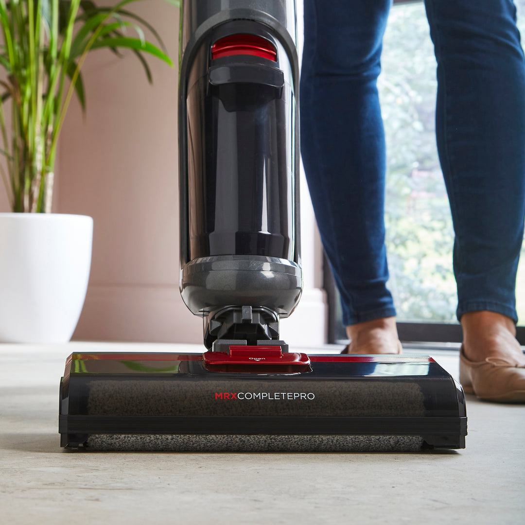 Person using Mrphy Richards floor cleaner on a wooden floor.