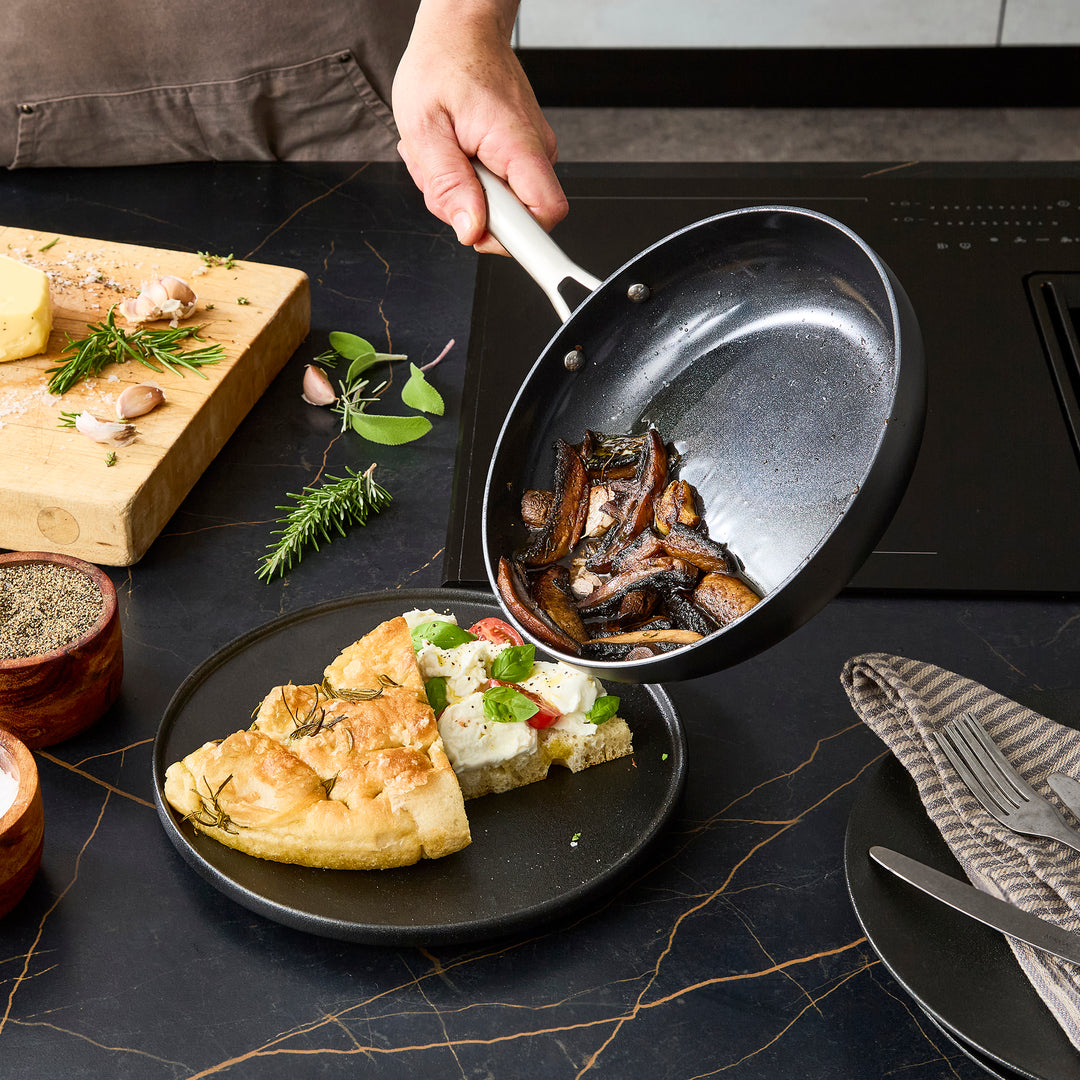 Tipping the fried mushrooms from the 24cm frying pan onto the plate