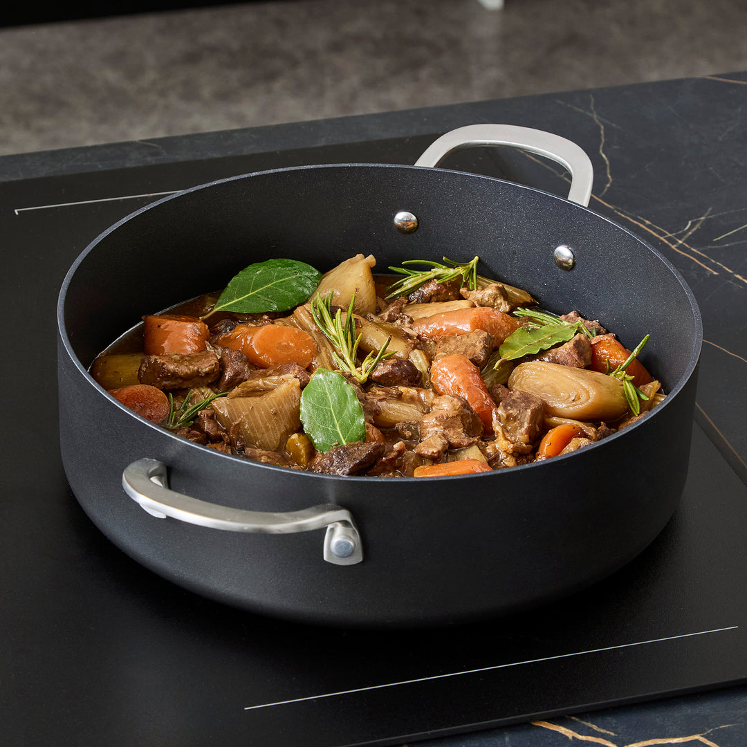 Beef stew inside the 28cm Aluminium Non-Stick Shallow Casserole Dish on an induction hob 
