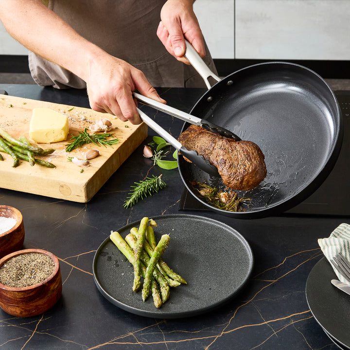 Tipping the steak from the 30cm frying pan to a plate