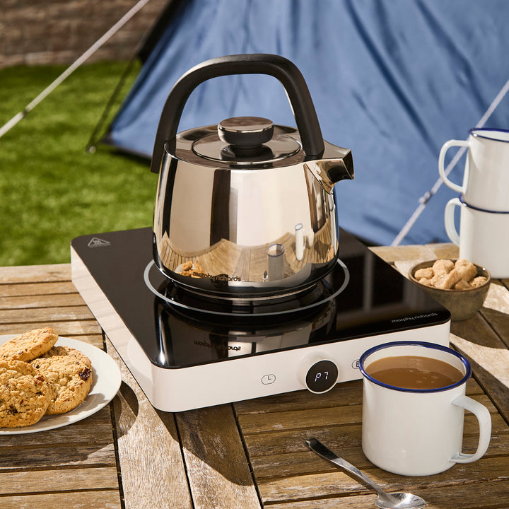 stovetop kettle on top of a single induction hob in an outdoor camping setting
