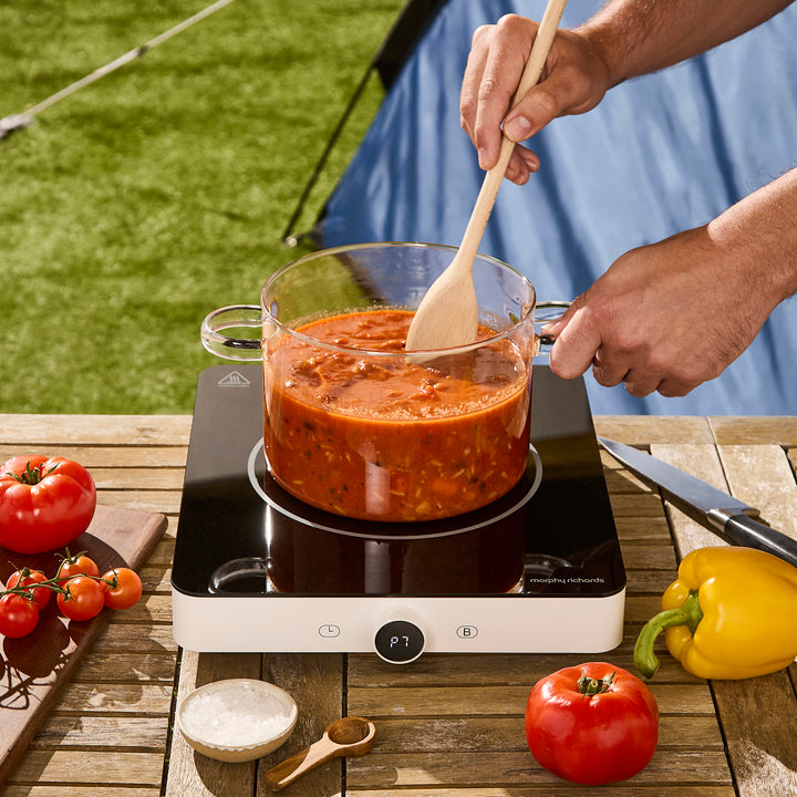glass saucepan on top if single induction hob in a garden setting