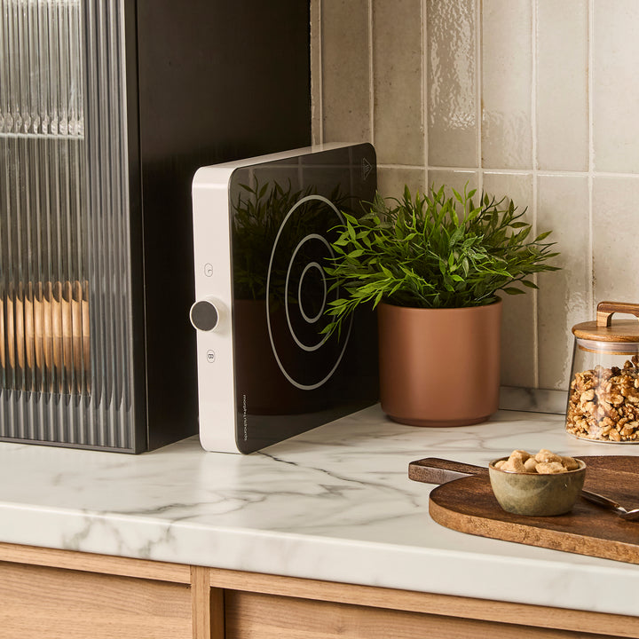 single induction hob propped next to a kitchen cupboard to show easy storage