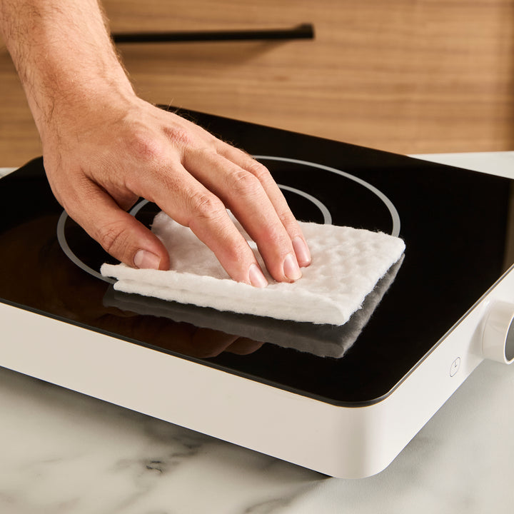 hand wiping single induction cooker with cloth