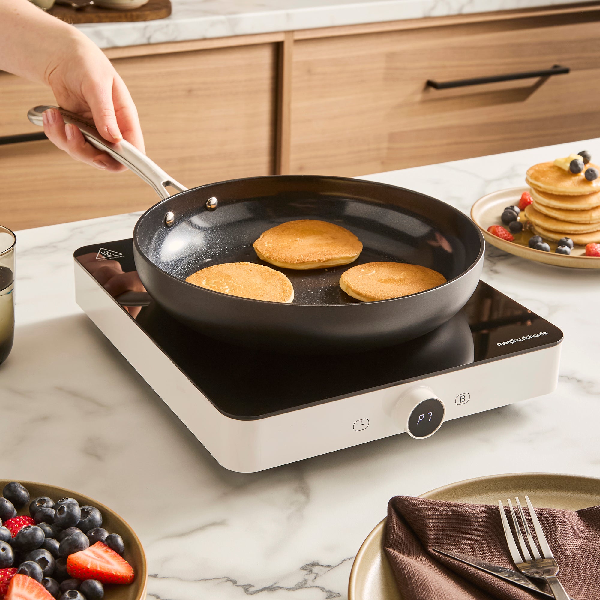 single induction hob with frying pan placed on top in a kitchen setting