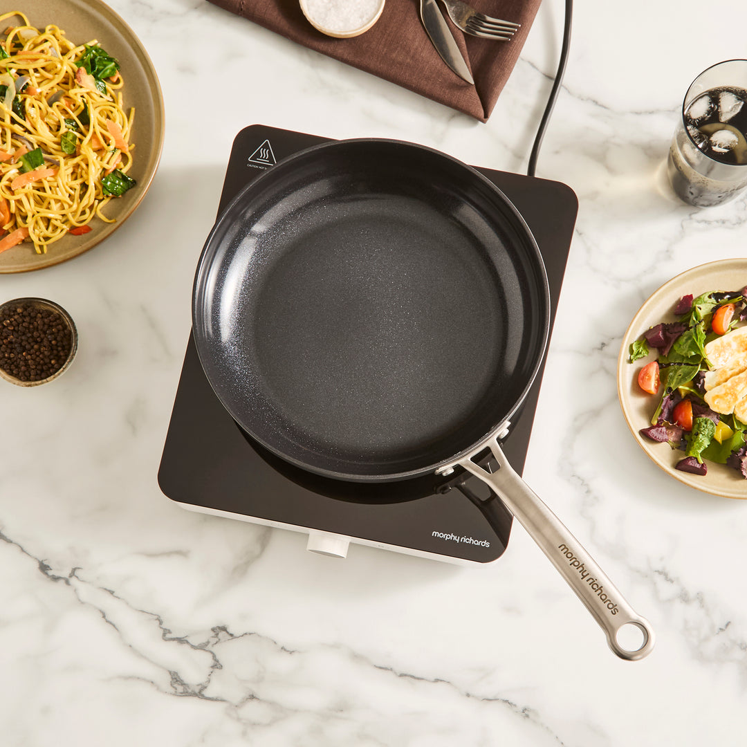 single induction hob with frying pan placed on top in a kitchen setting