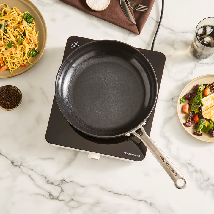 single induction hob with frying pan placed on top in a kitchen setting